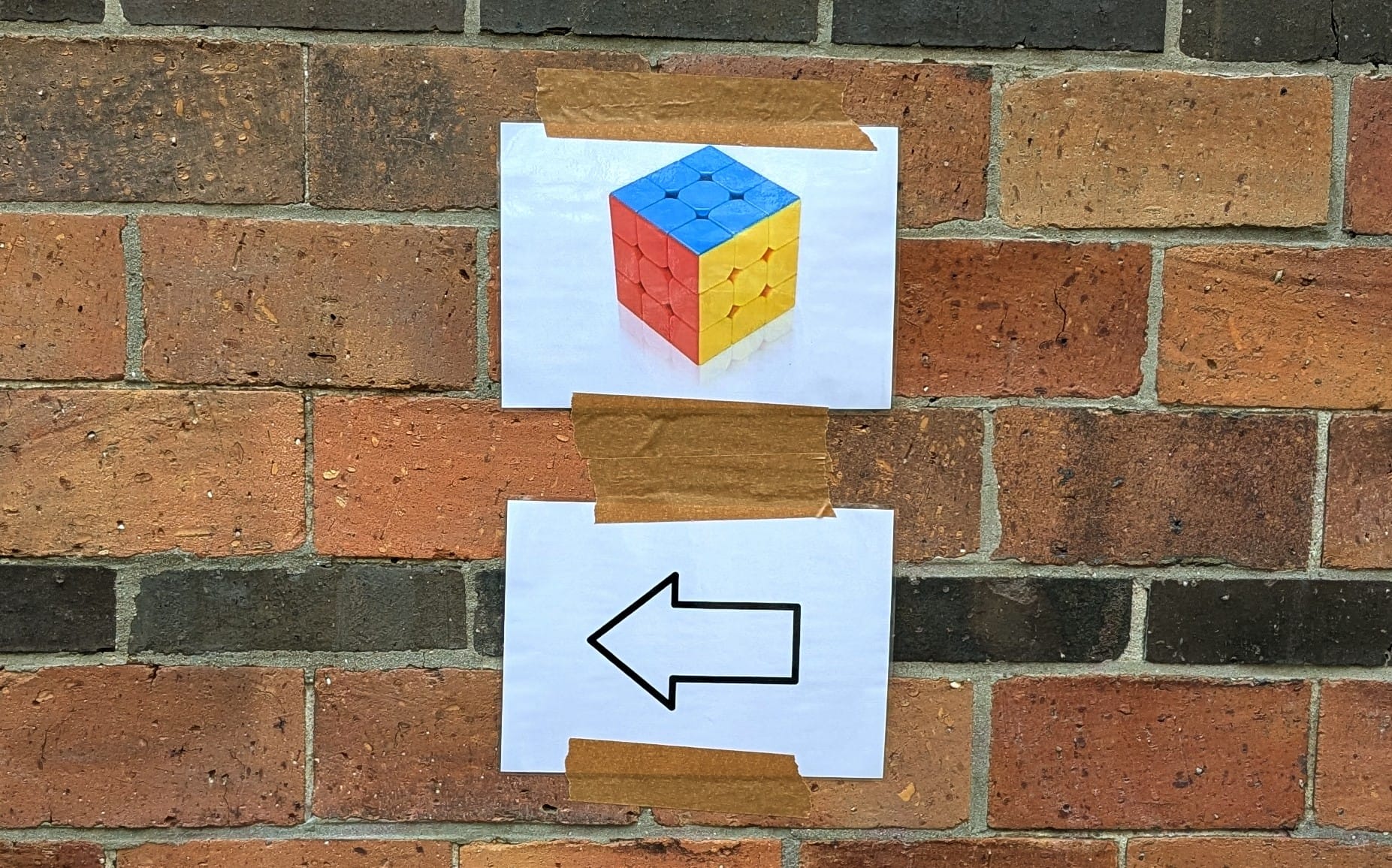 Speedcubing competition sign on a brick wall